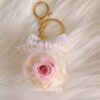 Preserved pink rose charm in clear acrylic case with pearls and ribbon
