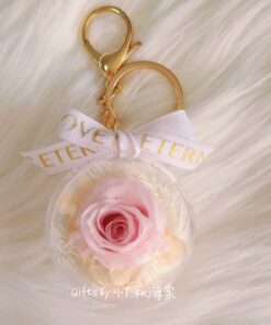 Preserved pink rose charm in clear acrylic case with pearls and ribbon