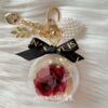 Preserved red rose charm in clear acrylic case with pearls and ribbon