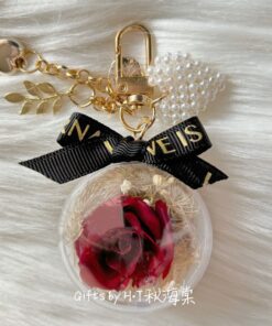Preserved red rose charm in clear acrylic case with pearls and ribbon
